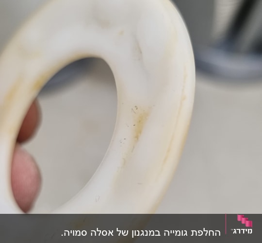 אצבע מחזיקה אטם גומי לבן עם כתמים